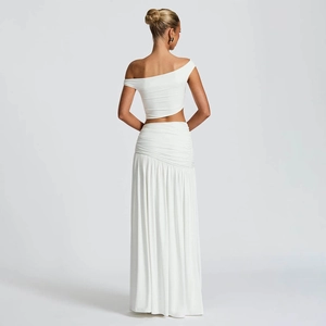 Detail view of the back of a white two-piece set featuring crop top and pleated maxi skirt