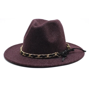 Detail of burgundy wool fedora hat with gold chain and black bow decoration