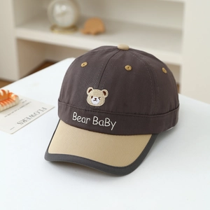 Detail of baby baseball cap with bear embroidery and contrast color visor on white table