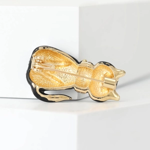 Reverse side of black and gold alloy cat brooch showing secure pin fastener details