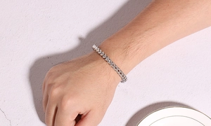 Detailed view of silver wheat chain stainless steel bracelet worn on male wrist