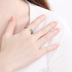 Detailed view of a silver snake-shaped open ring featuring textured scales on a model's hand