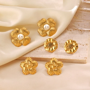 Three pairs of 18K gold plated floral stud earrings with pearls on a silk fabric background