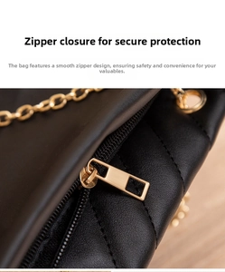 Close-up of golden zipper closure on black quilted leather mommy shoulder bag