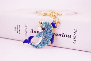 Detailed macro of golden crown dolphin keychain with sparkling blue rhinestones