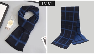 Detail of wool-like winter scarf featuring blue plaid pattern and soft fringed edges
