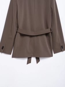 Detail view of brown blazer back with waist tie belt and split hem design