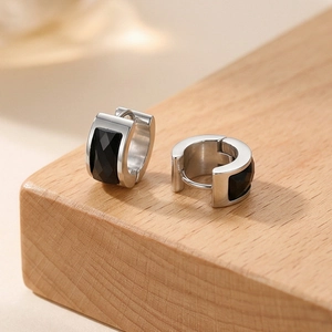 Detail of silver stainless steel hoop earrings with faceted rectangular black stone