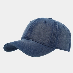 Detail view of deep blue denim fabric texture and stitching on a 6-panel baseball cap