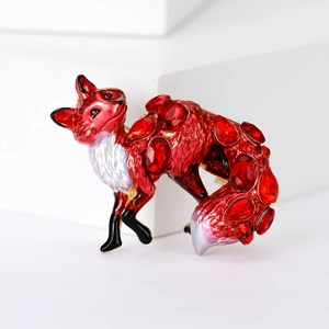 Macro shot of red enamel fox brooch with sparkling rhinestones on geometric background