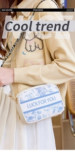 Detailed view of white crossbody bag with blue floral patterns and Luck For You text