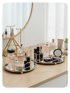 Detail of round gold metal mirrored tray with decorative sphere edges and wire fence frame