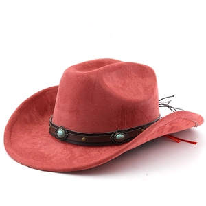 Détail d'un chapeau de cow-boy rouge avec bandeau en cuir brun et boucles turquoise