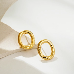 Detail of 18K gold-plated oval earrings featuring unique irregular wrinkled texture