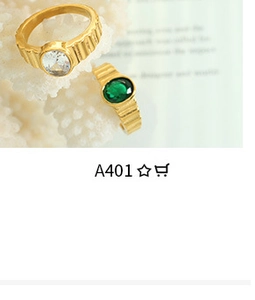 Detailed shot of gold plated textured rings with emerald and clear oval gemstones