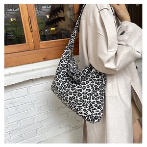 Street style view of a large capacity tote bag with black and white leopard print