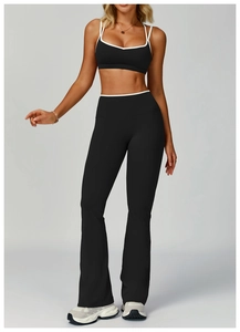 Vista dettagliata del reggiseno yoga nero e dei pantaloni svasati con bordi bianchi
