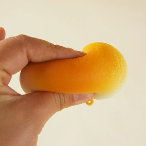 Slow rebound PU foam stress relief toy shaped like a golden bun being squeezed by hand