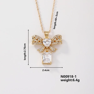 Detail showing dimensions of gold bow pendant necklace with zircon heart and rectangle stone