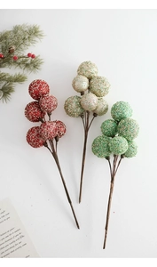 Detail of glittered Christmas berry picks in red, champagne gold, and green stems