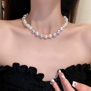Close-up of French style pearl necklace with silver-toned beads on model's neck