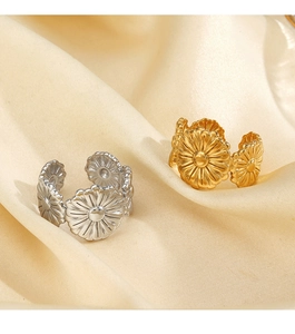 Macro detail of gold and silver daisy flower rings on elegant beige silk background