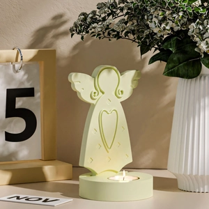 Close-up of mint green angel candle holder with embossed heart and warm tea light
