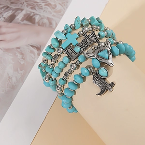 Detail of bohemian turquoise multi-layer bracelet with silver bull head and cross charms