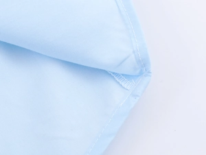 Macro shot of light blue fabric texture and professional stitching on the shirt edge