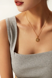 Detail of 18K gold-plated sun and moon pendant necklace with crystal pavé on model