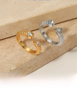 Macro shot of stainless steel textured ring with heart-shaped zircon stones on stone