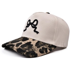 Cappellino da donna con ricamo a fiocco 3D e visiera leopardata su sfondo bianco