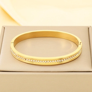 Close-up of 18K gold plated stainless steel bracelet with white zircon inlay on silk