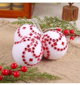 Dettaglio di palline di Natale in schiuma bianca con strass rossi e trama vellutata