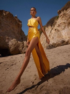 Detail of silk-satin yellow dress featuring a waist cutout and a high side leg slit