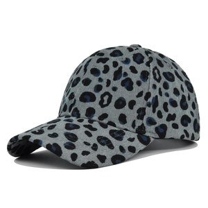 Detailed view of light grey corduroy baseball cap with dark blue leopard print patterns