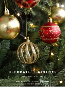 Close-up of red and gold Christmas ornaments with glitter and star patterns on a tree