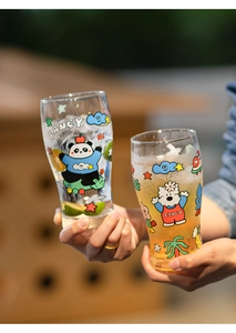 Close-up of large glass beer mugs with colorful panda prints and iced drinks