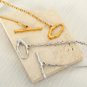Irregular OT buckle necklace with gold and silver snake chain on marble stone