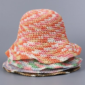 Detail of hand-woven straw sun hats showing crochet texture and wavy brim in mixed colors