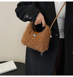 Detail of plush brown tote bag featuring leather handles and a silver metal twist-lock