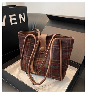 Detail of vintage red plaid wool tote bag with premium brown leather handles in gift box