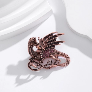 Macro detail of bronze dragon brooch with inlaid purple rhinestones on a white background
