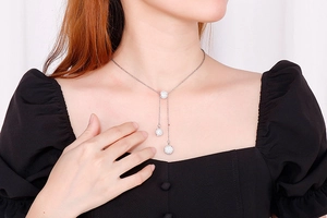 Detail of silver stainless steel Y-necklace with three crystal-encrusted sphere pendants