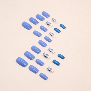 Deep sea blue square press-on nails with glitter and butterfly patterns on beige background