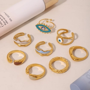Evil Eye enamel rings and hammered gold open bands collection on elegant neutral background