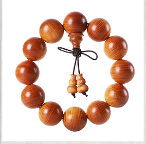 Macro detail of natural cedar wood prayer beads showing authentic grain patterns and gourd charm