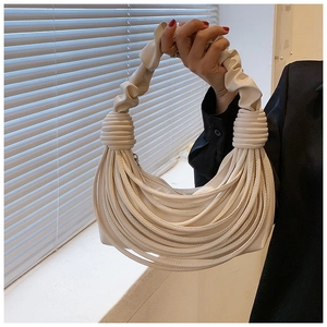 Detail of off-white pleated PU leather handbag with knot tassel handle and half-moon shape