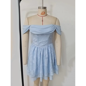 Détail de robe bleu clair à épaules dénudées avec fleurs 3D et jupe à plusieurs couches
