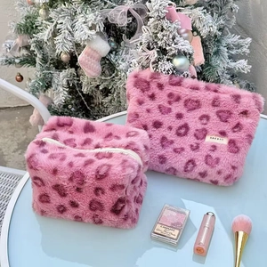 Pink leopard faux fur makeup bag set with zipper and plush texture on a holiday table